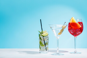 A variety of cocktails arranged on a table against a light blue background