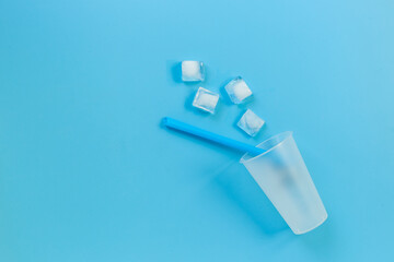 Disposable cup with ice and straw for cocktails. Cold drink concept