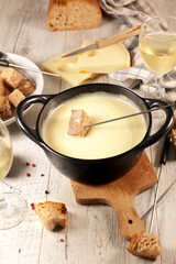 cheese fondue with bread and glass of wine. Traditional french dish
