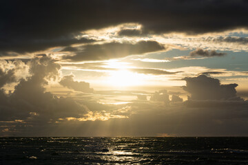 Seascape at sunset, the Baltic Sea and the sun breaking through storm clouds.