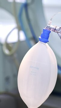 Moving ambu bag with connected tubes hanging in the surgery room. Close up. Blurred background. Vertical video