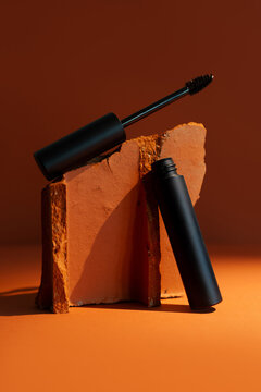 Close-up mockup of empty smooth mascara with delicate brush on soft, blurry, expensive background. Elegant brick effect adds a touch of luxury, perfect for beauty and makeup themes.