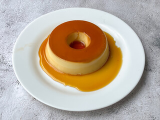 Delicious caramel-topped milk pudding on a white plate.