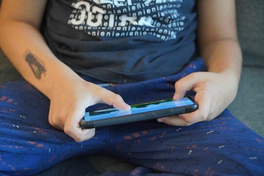 Young boy playing Minecraft on a smartphone