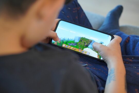 Young boy playing Minecraft on a smartphone