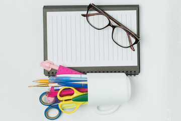 A vibrant collection of office and school supplies, including scissors, pens, sticky notes, paper...
