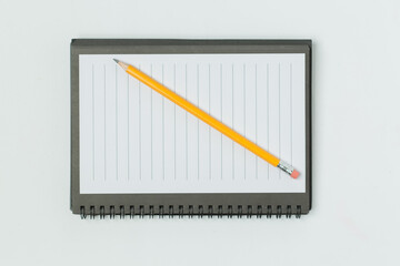  Notepad with pencil on a white surface.