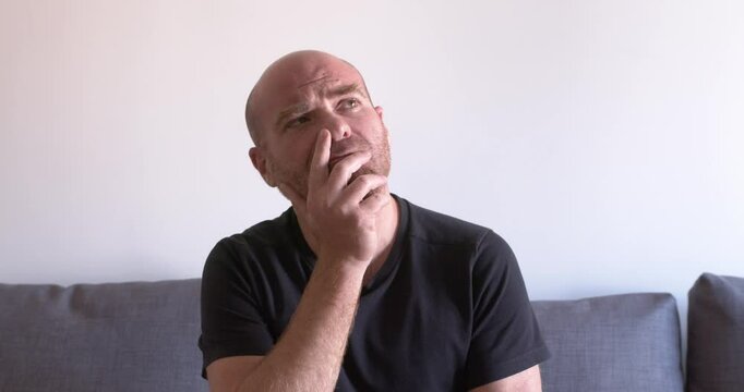 Pensive mature man looks up, searching for solution
