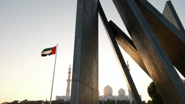  Wahat Al Karama Park at sunset, with golden light casting warm glow over serene landscape. iconic Sheikh Zayed Mosque in background