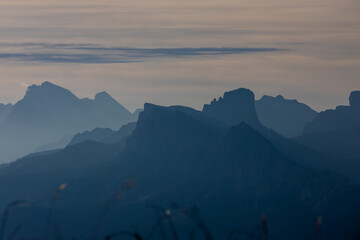 A misty sky with mountain silhouettes on the horizon creates a serene photography setting. Features soft gradients, layered peaks, and atmospheric tones, ideal for capturing tranquil landscapes