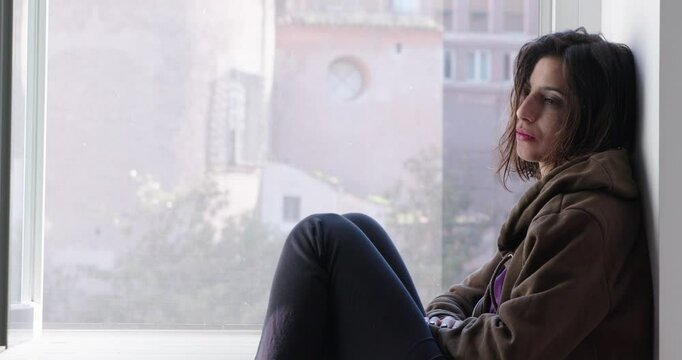 Girl curled up, sad and hurt, staring into space