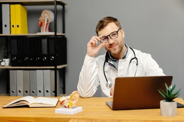 Doctor sitting at desk with laptop