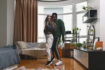 Young couple practicing modern dance in the room at home