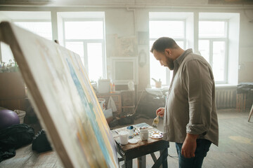 Focused male painter working on a new artwork
