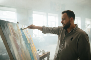 Focused male painter working on a new artwork
