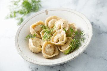 Homemade dumplings with butter and dill