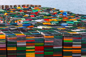 Large number of stacked plastic crates in various colors. Crates are arranged in an orderly manner, with some stacks wrapped in plastic, likely indicating they are ready for transport or storage