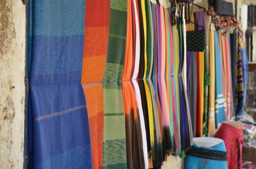 Colorful scarves and fabrics hanging on display in Essaouira, Morocco, with a wide variety of...