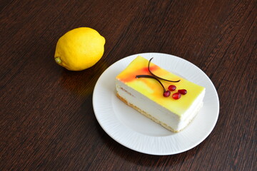 a slice of cheesecake with a design on it on a plate next to a lemon