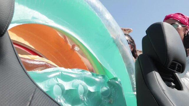 Two Women Going To The Beach Put The Floaters In The Car. - handheld shot