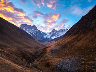 Fotobehang Autumn golden complex hills with amazing Caucasus mountains background, walking view at Juta, Georgia country. Brown and yellow colors mountain with stream, beauty sunrise landscape in the morning. © tete_escape