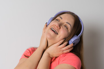 Modern woman smiling with braces on her teeth and listening to music