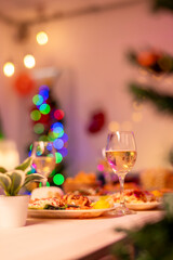 A table with a variety of food and drinks, including a glass of wine