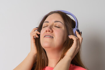 Fototapeta premium Modern woman smiling with braces on her teeth and listening to music