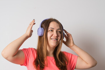 Fototapeta premium Modern woman smiling with braces on her teeth and listening to music