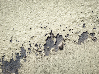 Yellow paint on the building cement wall is peeling off. Home maintenance and renovation. Flaking color.
