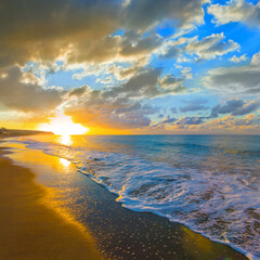 emerald sea bay with sandy beach at the dramatic sunset