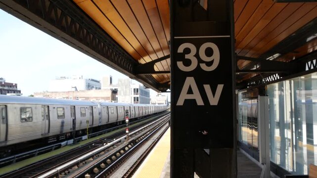 New York subway station. Metro train on metropolitan platform, United States public transportation. Elevated outdoor railway N line, Queens. NYC passenger railroad traffic, 39 avenue Long Island City