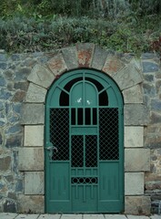 green rounded door with decorative stones around
