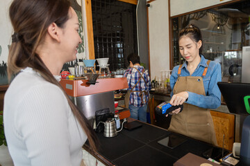 Close-up baristas or cashier worker hold payment machine accept credit card cashless transactions from customers, Smart business owner hand payment scanner to customers in cafe shop to pay for coffee