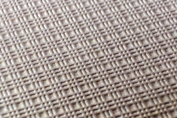 Detailed texture of a woven fabric, showcasing a grid pattern with subtle light reflections.