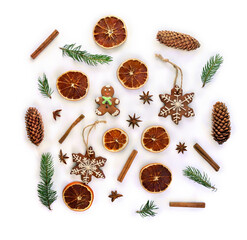 Christmas decoration. Christmas tree, christmas gingerbread, cones spruce, dried oranges, cinnamon sticks and stars anise on a white background with space for text. Top view, flat lay