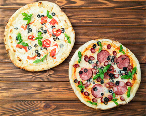 2 pizza with mozzarella cheese , salami sausages , olives , chicken , pineapple and tomatoes