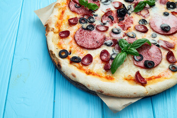 Pizza with mozzarella cheese , salami sausages , olives , and basil