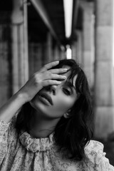 Black and white photo of a girl in classic clothes posing on the streets of Bangkok.