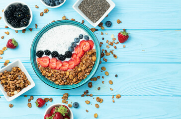 Healthy breakfast . Yogurt with berries ( strawberry , raspberry , blueberry , blackberry ) , granola and chia seeds . Top view