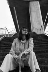 Black and white photo of a girl in classic clothes posing on the streets of Bangkok.