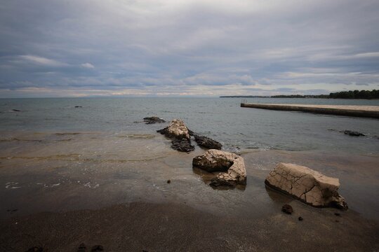 rocks in clear water under a cloudy sky at the Adriatic Sea coast in Umag, Croatia