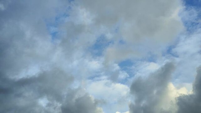Time lapse with dark and white clouds moving across blue sky. Meteorology and weather footage