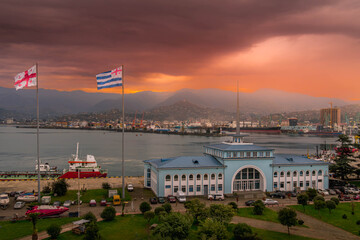 The view of Batumi seaport, Georgia, with the port terminal building, flags of Georgia and Republic of Adjara, during the beautiful sunset.
