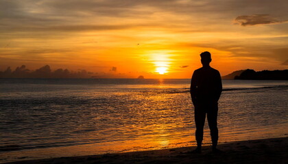 silhouette man standing on the beach with sunset view
