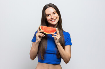 Beautiful brunette with a blue top enjoying a slice of watermelon. On white background.