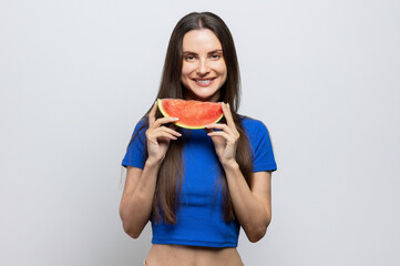 Beautiful brunette with a blue top enjoying a slice of watermelon. On white background.