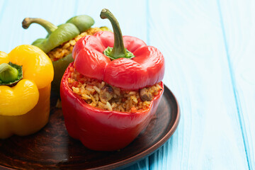 Baked stuffed pepper ( paprika ) with rice , carrot and meat . Top view on rustic background