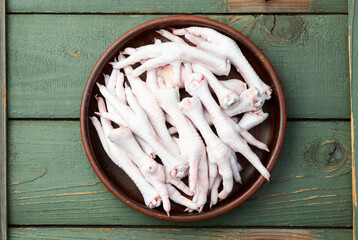 Raw chicken foot ( paws ) Top view on rustic background