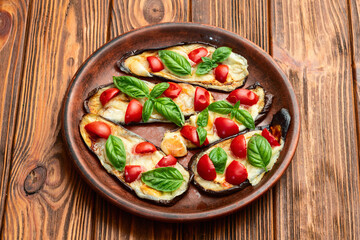 Italian mini pizza . Aubergine (eggplant ) with mozzarella cheese and basil . On rustic background